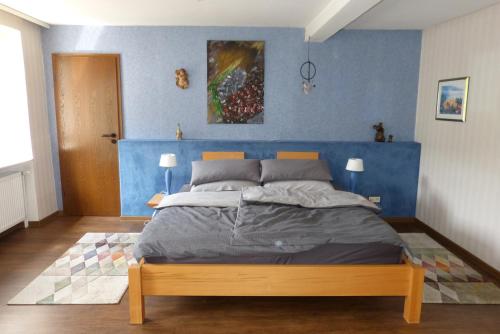 a bedroom with a bed with a blue wall at Schreiner in Daun