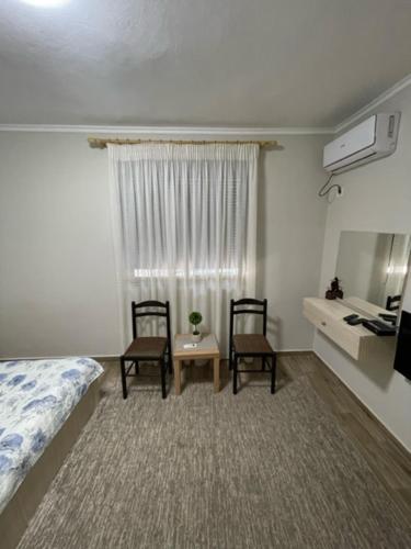 a bedroom with two chairs and a bed and a table at New Bazaar Rooms in Tirana