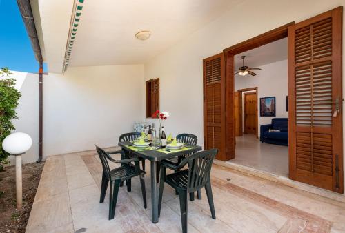 a dining room with a black table and chairs at Casa Vacanza Azzurra 2 in San Vito lo Capo