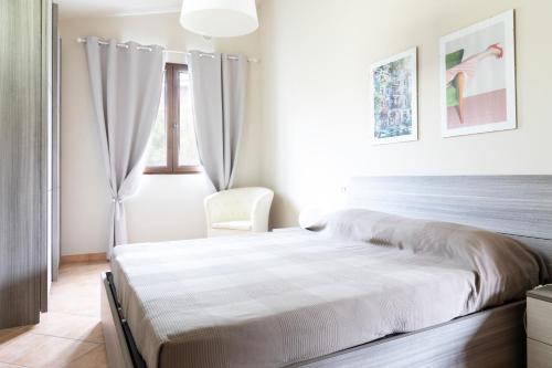 a white bedroom with a bed and a window at Appartamento La Terrazza in Portoferraio