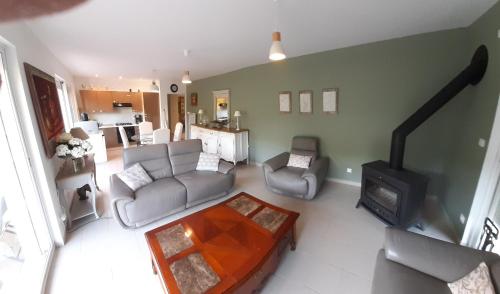 - un salon avec un canapé et une cuisinière dans l'établissement Adorable maison d’hôtes bordée d’étangs au calme., à Grandcourt