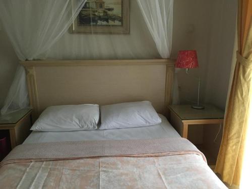 a bedroom with a bed and a lamp on a table at Melaike Hotel in Foça