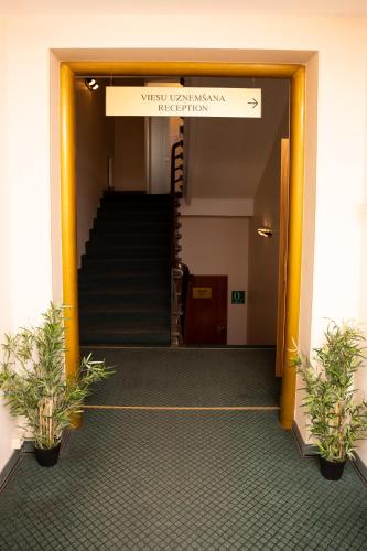 a hallway with stairs and a sign in a building at Avitar in Rīga