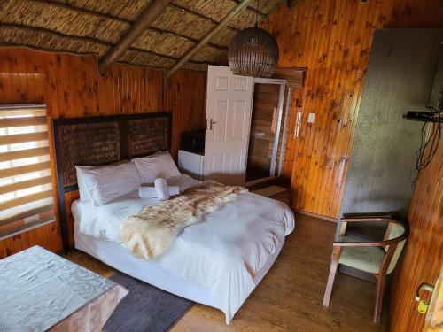 a bedroom with a bed and a chair in a room at Lauren Palace Guest House in Vanderbijlpark