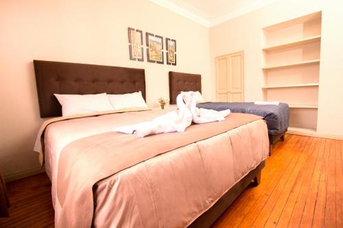 ein Schlafzimmer mit einem großen Bett mit Handtüchern darauf in der Unterkunft Hostal Virreinal AQP in Arequipa