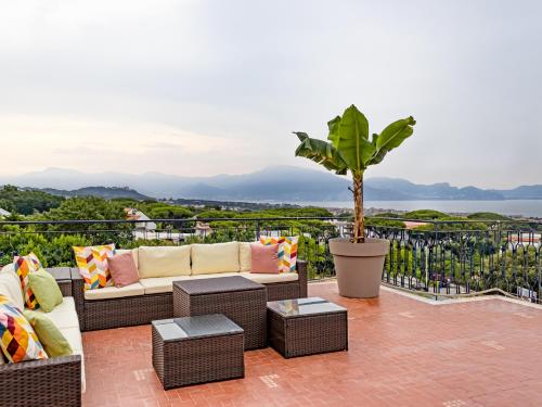 eine Terrasse mit Korbmöbeln und einer Topfpflanze in der Unterkunft Panorama Love to Stay in Ercolano