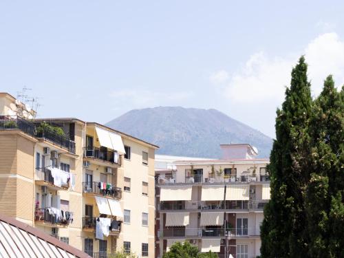 an apartment building with a mountain in the background at Panorama Love to Stay in Ercolano