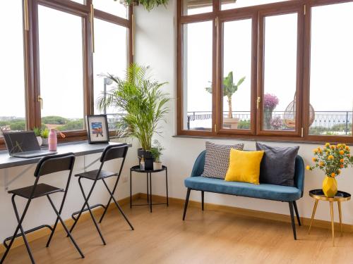 Habitación con silla azul, escritorio y ventanas. en Panorama Love to Stay en Ercolano