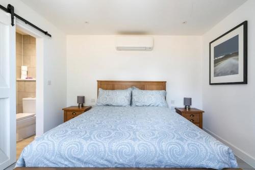 1 dormitorio con 1 cama con edredón azul en the Beach House en Kent