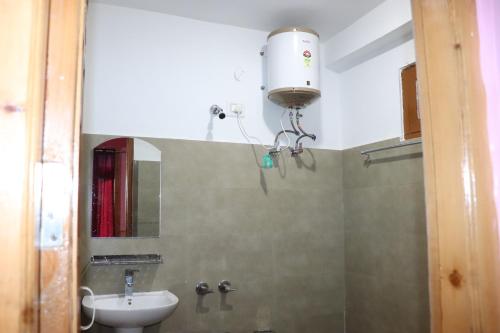 ein Badezimmer mit einem Waschbecken, einem WC und einem Spiegel in der Unterkunft Shesh Besh Guest House & Restaurant in Kasol