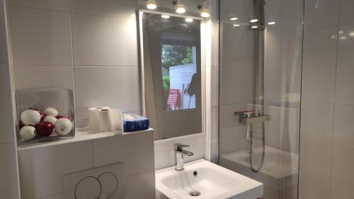 Baño blanco con lavabo y espejo en Belle Suite Apt, en Biarritz
