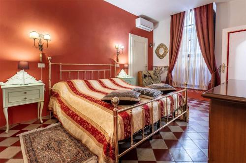 1 dormitorio con 1 cama grande y paredes rojas en Casa Quintani, en Cortona