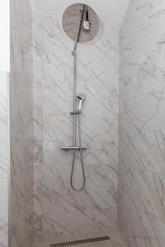 a shower in a bathroom with marble walls at Villa Ševo Baška Voda in Baška Voda