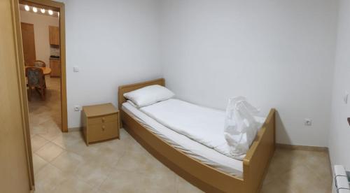 a small bed in a room with a night stand at Apartmani Kuprešak in Banja Vrućica