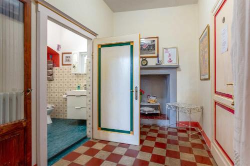 a bathroom with a door open to a bathroom with a fireplace at Casa Quintani in Cortona