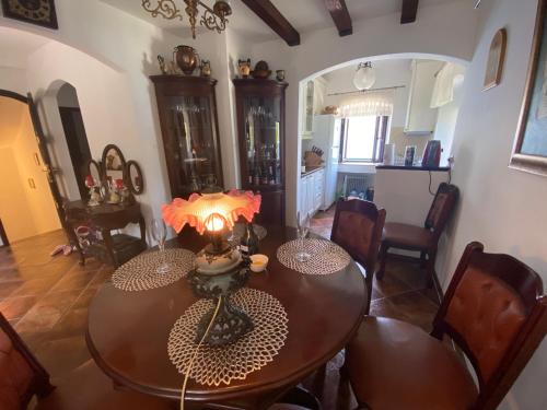 a dining room with a table and chairs and a kitchen at House with a pier in Donji Morinj