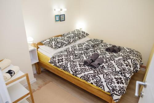 a bedroom with a bed with black and white sheets at ĐILL Apartment in Subotica