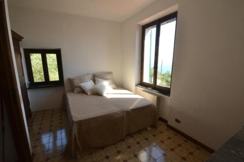 sypialnia z łóżkiem i 2 oknami w obiekcie Holiday Home Chiavari w mieście Chiavari