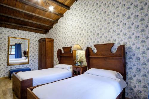a bedroom with two beds and a mirror at Aldea A Paínza in Arzúa