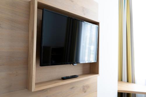 a flat screen tv on a wall in a room at Villa Benz Hotel garni in Schwetzingen