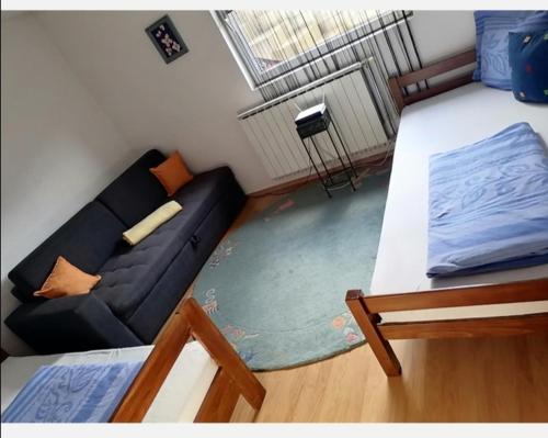 - un salon avec un canapé et un lit dans l'établissement Apartment AMRA, à Tuzla
