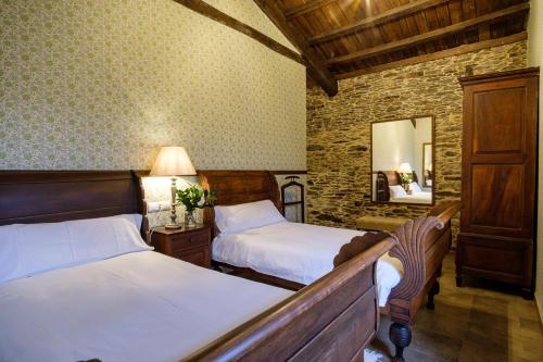 a bedroom with two beds and a mirror at Aldea A Paínza in Arzúa