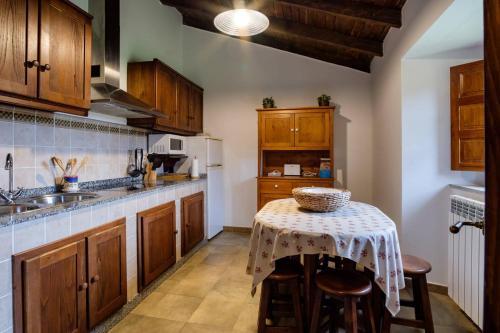 a kitchen with wooden cabinets and a table with chairs at Aldea A Paínza in Arzúa