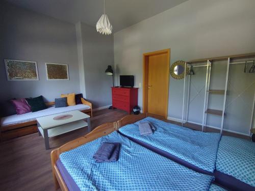 ein Schlafzimmer mit einem blauen Bett und einem Sofa in der Unterkunft Haltestelle - Private Zimmervermietung Röbel Müritz in Röbel