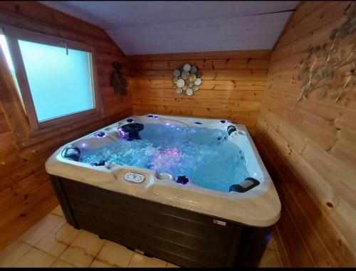 Cette chambre en bois dispose d'un bain à remous et d'une fenêtre. dans l'établissement Ô refuge di’vin, à Bannay