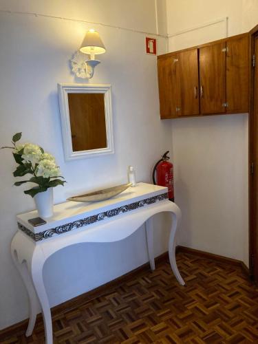 a bathroom with a white sink and a mirror at Apartamento Trav. Santa Luzia in Mirandela