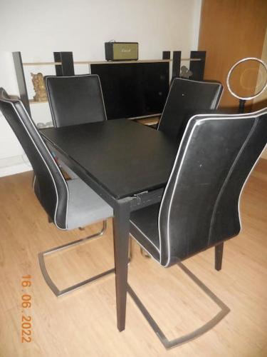 une table à manger noire et quatre chaises noires dans l'établissement Grand studio à 2 pas de la mer, à Saint-Cyr-sur-Mer