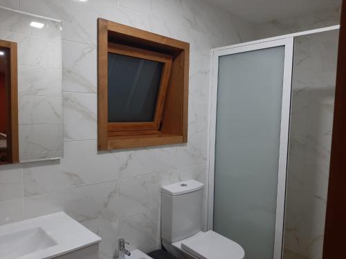 uma casa de banho com um WC, um lavatório e um espelho. em Estúdio de Amor em Castelo de Paiva