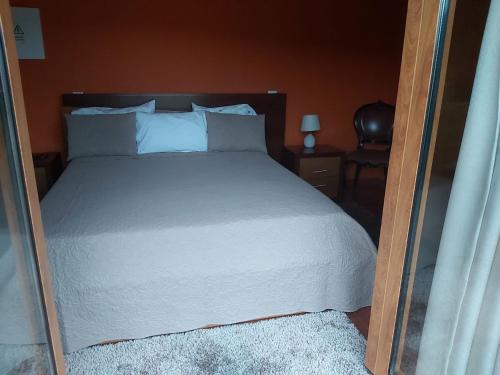 a bedroom with a white bed with a mirror at Estúdio de Amor in Castelo de Paiva