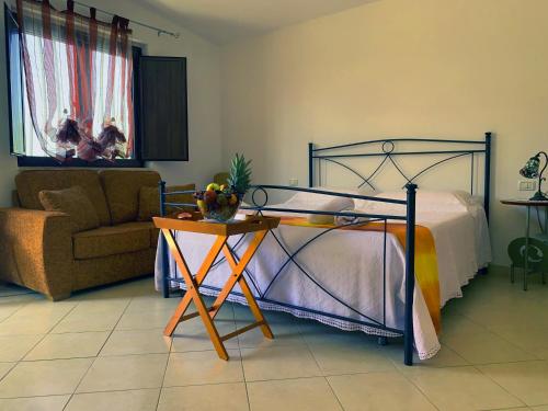 a bedroom with a bed and a table and a chair at Villa parco la Ruta, Piscina e relax in Noci