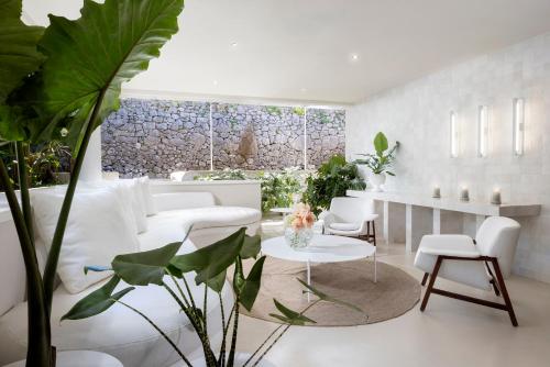 a living room with white furniture and plants at Jumeirah Capri Palace in Anacapri
