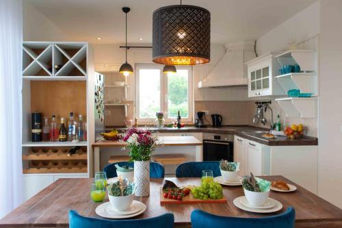une cuisine avec une table en bois et des chaises bleues dans l'établissement Into The Blue, à Kostrena