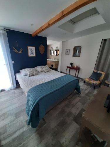 une chambre avec un lit et un mur bleu dans l'établissement La Colinière, Chambre d'hôtes, à Aix-en-Provence