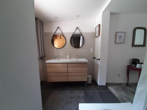 une salle de bain avec un lavabo et deux miroirs dans l'établissement La Colinière, Chambre d'hôtes, à Aix-en-Provence