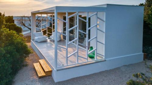 a small blue building with a glass wall at Macchia Piccinna in Maruggio