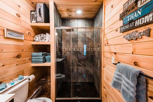 een badkamer met een douche en houten wanden bij SkyView treehouse in Belgrade
