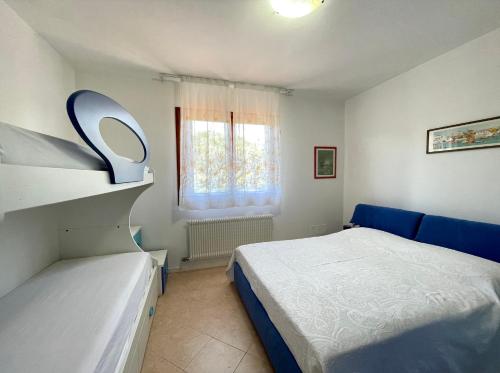 um pequeno quarto com uma cama e uma janela em Appartamenti Valle Dolce Carraro Immobiliare - Family Apartments em Cavallino-Treporti