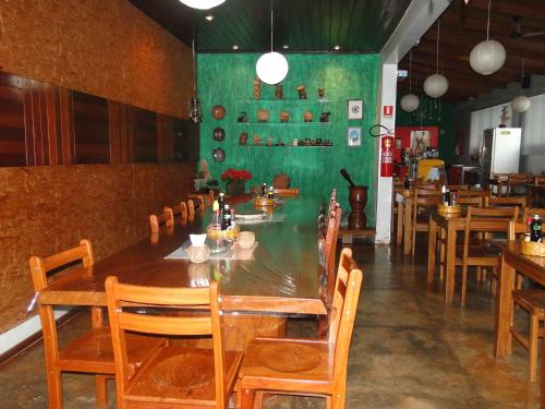 Tucuma的住宿－Hotel da Gaúcha，一间带长桌和木椅的用餐室