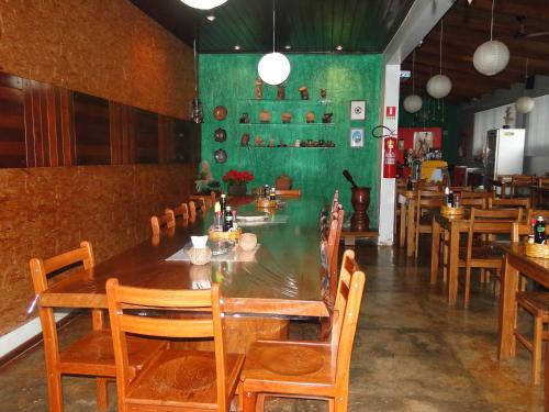 a dining room with a long table and wooden chairs at Hotel da Gaúcha in Tucuma