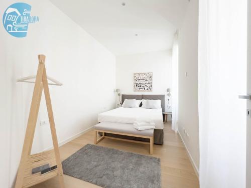 Habitación blanca con cama y alfombra en Slataper 12 Tirabora Short Rent, en Trieste