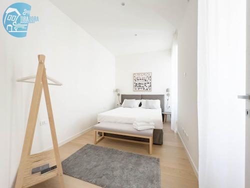 a white bedroom with a bed and a rug at Slataper 12 Tirabora Short Rent in Trieste