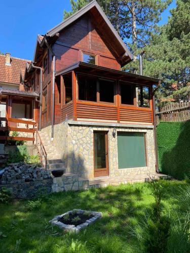 a wooden house with a yard in front of it at Brvnara Ljubomir, planina Tara, Kaludjerske Bare in Kaludjerske Bare