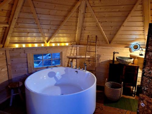 Auriac-sur-Vendinelle的住宿－Les Etoiles de Morphée，一个带木制天花板的房间内的大浴缸