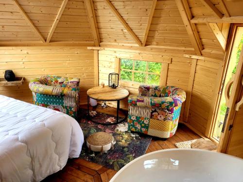 a bedroom with a bed and two chairs and a table at Les Etoiles de Morphée in Auriac-sur-Vendinelle