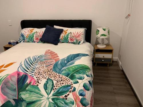 a bedroom with a bed with a leopard and tropical pillows at North Hobart, Tranquil Retreat, No Stairs, Access in New Town