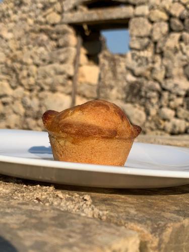 a muffin sitting on a plate on a table at Masseria Petra in Martano